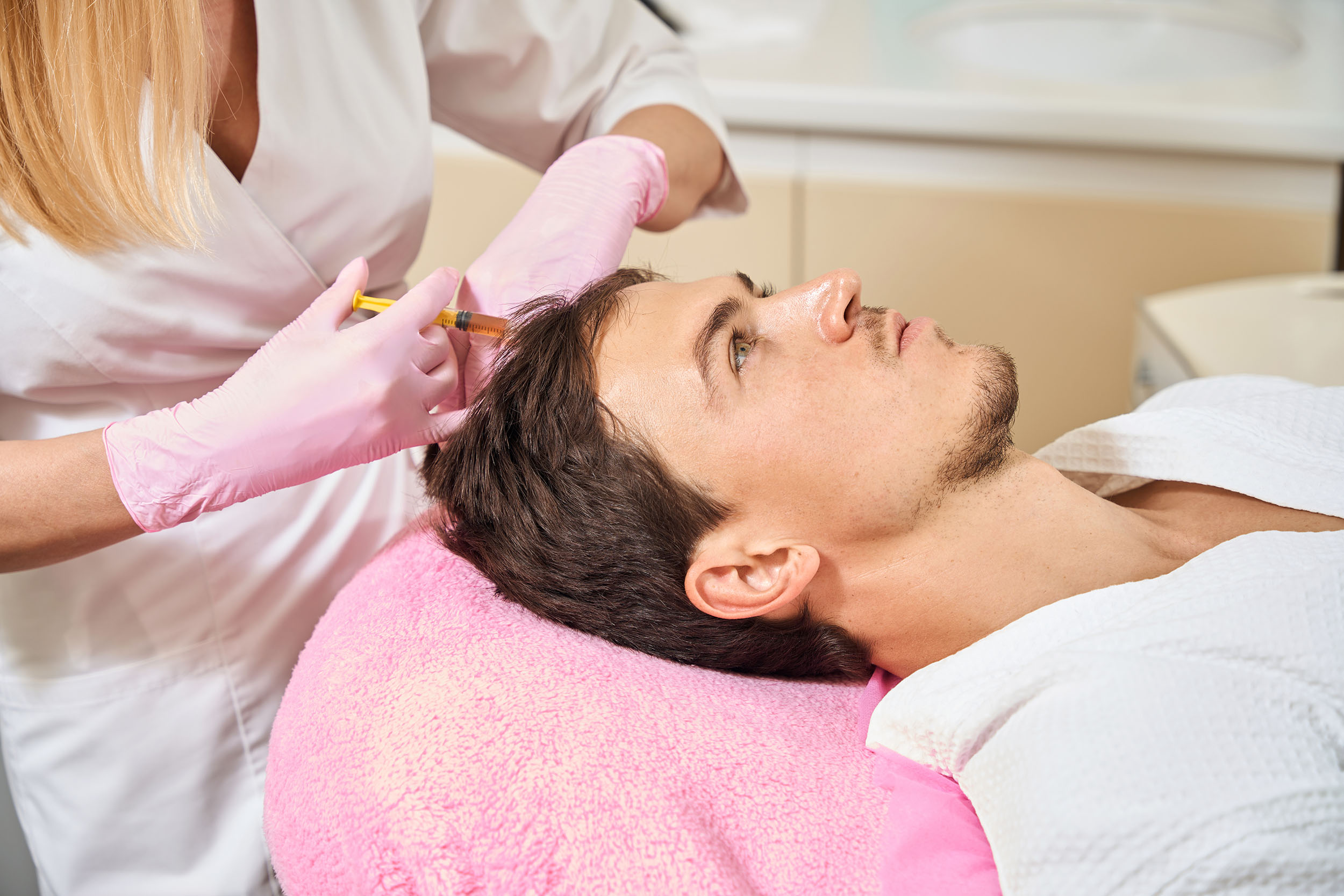 A man receives PRP hair restoration at a med spa.