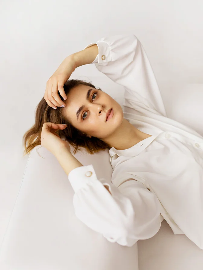 Woman in white shirt with towel wrapped on head against neutral background in spa setting - PRP exosomes in Tampa, FL