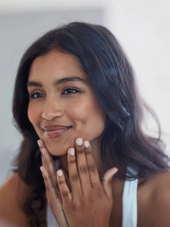Woman with natural makeup showing off white manicured nails while smiling at camera - Xerf in Tampa, FL
